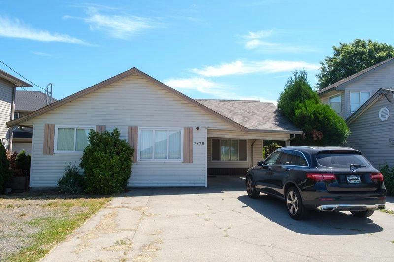 A small suburban house with driveway and car